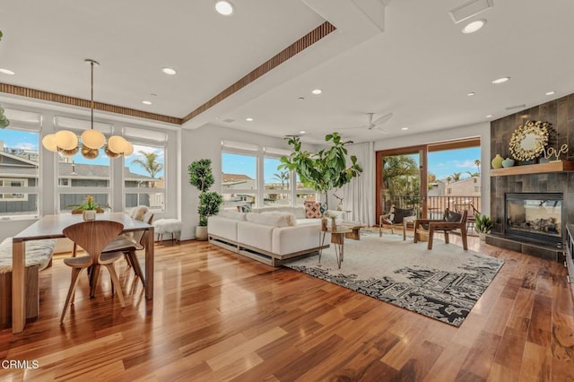 living room with recessed lighting, a multi sided fireplace, wood finished floors, and visible vents