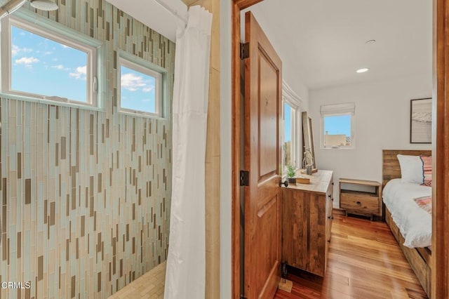 interior space featuring recessed lighting, tiled shower, ensuite bathroom, and wood finished floors