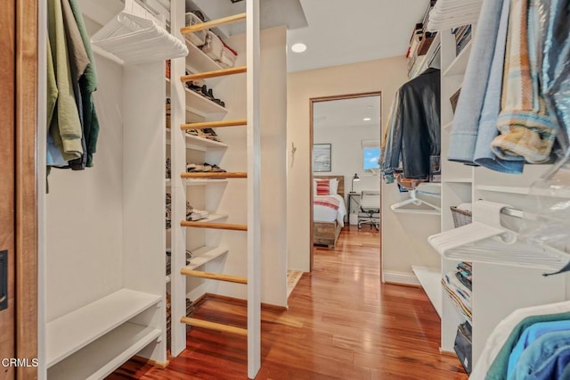 walk in closet with wood finished floors