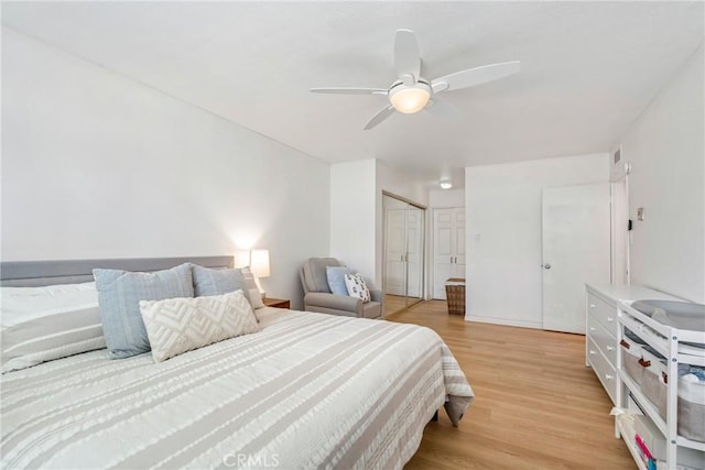 bedroom featuring light wood-style floors, ceiling fan, and visible vents