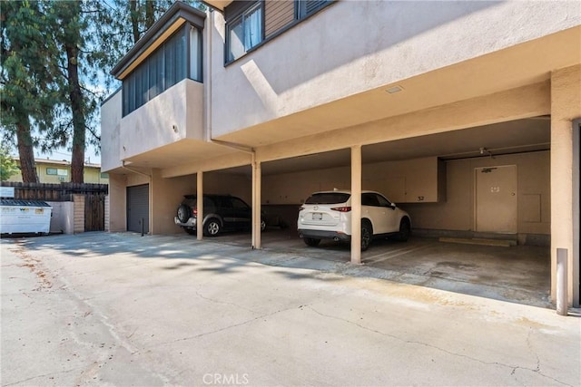 covered parking lot featuring fence
