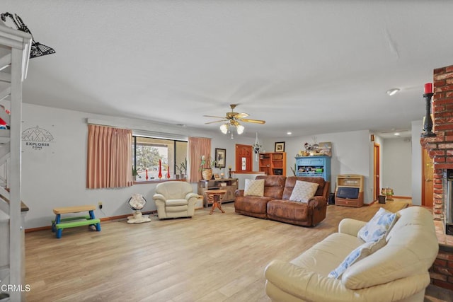 living area with ceiling fan, a brick fireplace, wood finished floors, baseboards, and recessed lighting