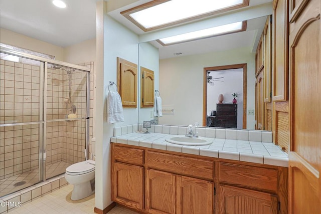bathroom with vanity, ceiling fan, a stall shower, and toilet