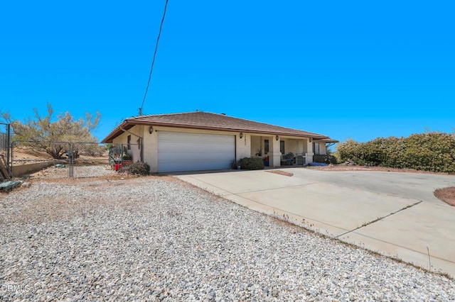 ranch-style home featuring covered porch, fence, concrete driveway, an attached garage, and stucco siding