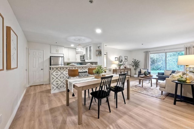 dining space featuring light wood-style floors, recessed lighting, and baseboards