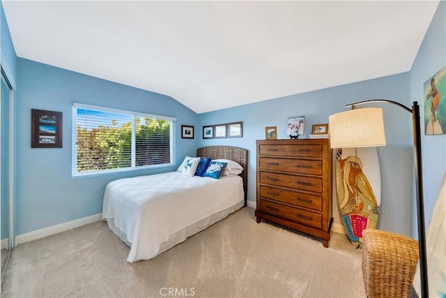 carpeted bedroom with baseboards and vaulted ceiling