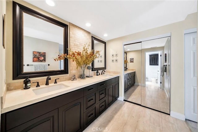 full bath with a sink, backsplash, recessed lighting, and double vanity