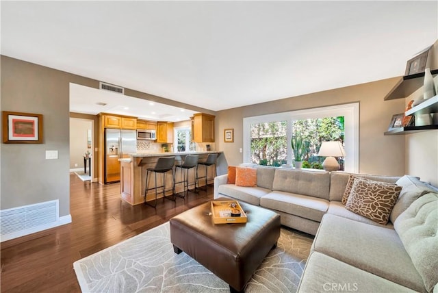 living area featuring recessed lighting, baseboards, dark wood-style flooring, and visible vents
