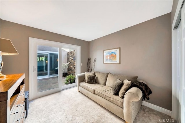 living room featuring baseboards and light colored carpet
