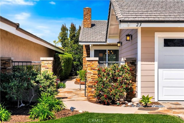 property entrance with a chimney and a tile roof