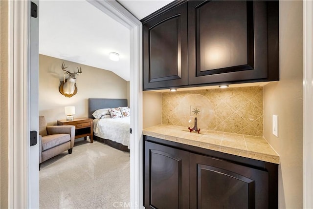 bedroom with light colored carpet and lofted ceiling