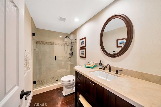 bathroom featuring visible vents, a stall shower, wood finished floors, vanity, and toilet