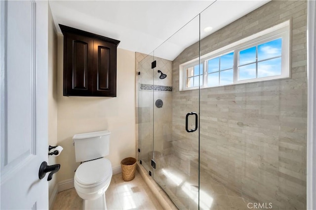 bathroom with baseboards, lofted ceiling, toilet, and a shower stall