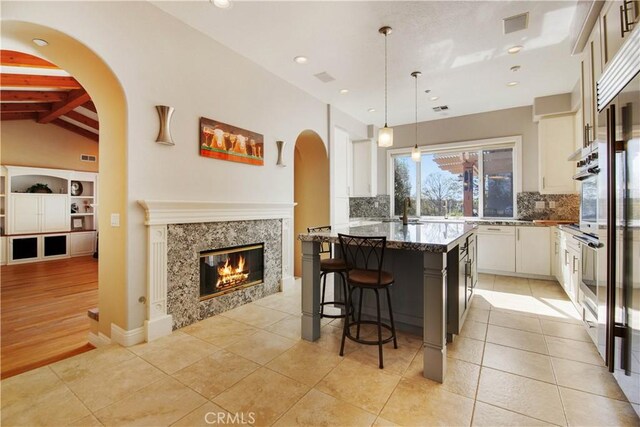 3988 Keri Way, Fallbrook, CA 92028 - kitchen with decorative backsplash, a breakfast bar, a center island, dark stone countertops, and recessed lighting