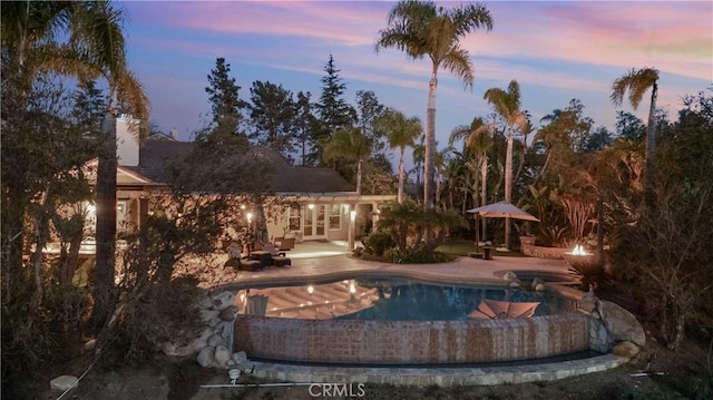3988 Keri Way, Fallbrook, CA 92028 - pool at dusk with a patio, an outdoor pool, an in-ground hot tub, and french doors
