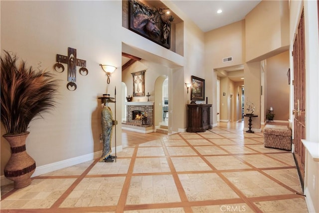 3988 Keri Way, Fallbrook, CA 92028 - entrance foyer with inlaid floor details, arched walkways, a brick fireplace, a high ceiling, and recessed lighting