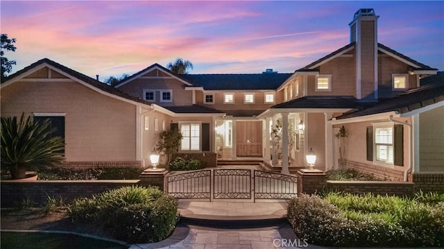 3988 Keri Way, Fallbrook, CA 92028 - back of house at dusk featuring a fenced front yard, brick siding, a gate, and a chimney