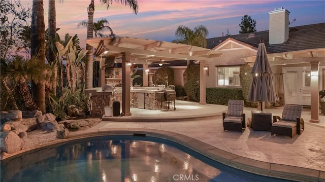 3988 Keri Way, Fallbrook, CA 92028 - pool at dusk featuring a pergola, a patio area, an outdoor pool, and exterior kitchen