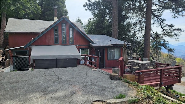 15 Ponderosa Pike, Running Springs, CA 92382 - view of front of house featuring a hot tub, a wooden deck, an attached garage, driveway, and roof with shingles