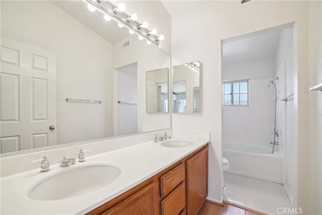 bathroom featuring a sink, toilet, double vanity, and visible vents