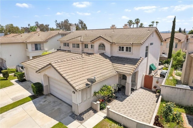 view of front of property featuring an attached garage, stucco siding, driveway, and a tiled roof