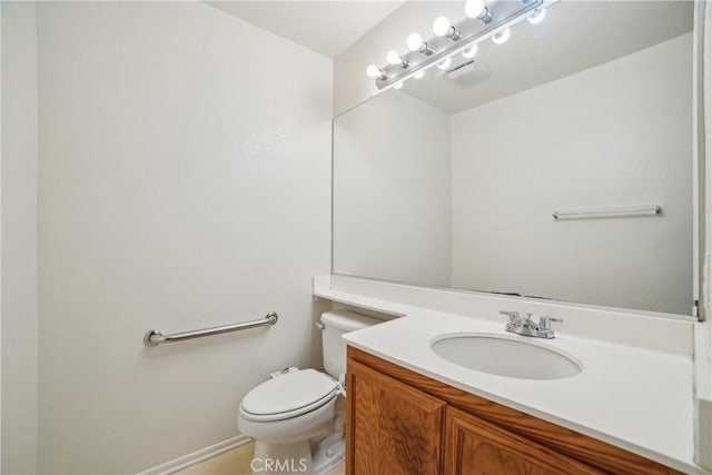 half bath with vanity, baseboards, and toilet