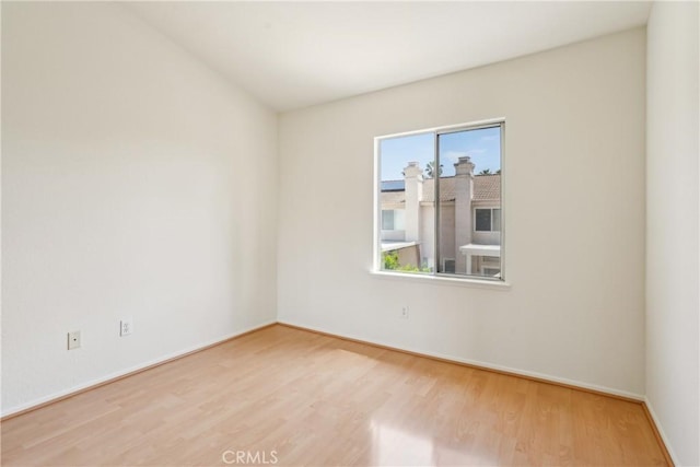 unfurnished room featuring baseboards and wood finished floors