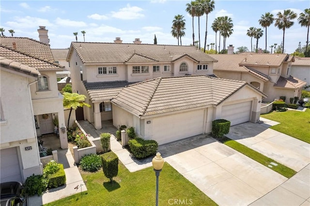 view of front facade featuring concrete driveway, a tiled roof, an attached garage, and stucco siding