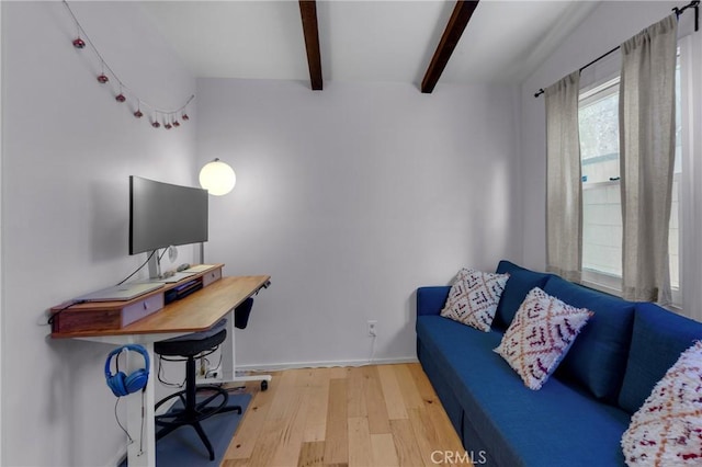 office area with baseboards, beam ceiling, and wood finished floors