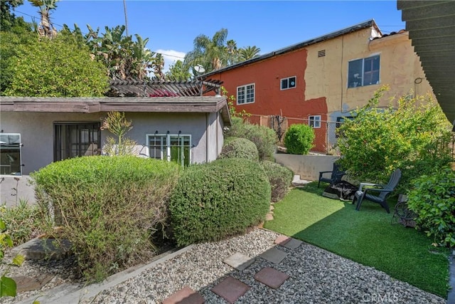 exterior space with fence, stucco siding, and a yard