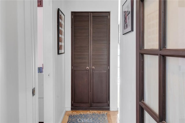 hallway featuring baseboards and light wood-style floors