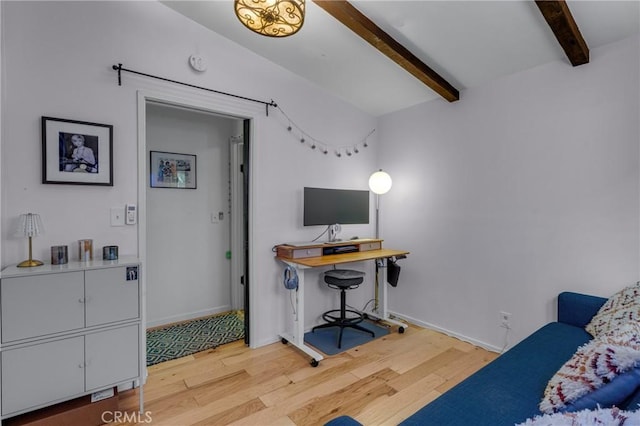 home office featuring baseboards, beam ceiling, and light wood-style floors