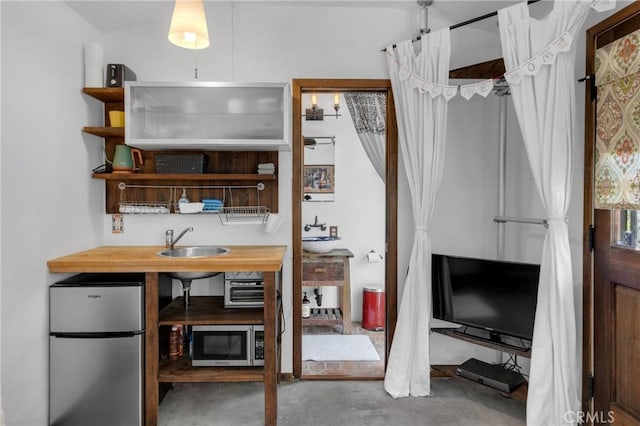 office area with unfinished concrete flooring and a sink