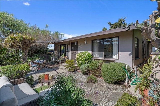 view of front of property with an outdoor hangout area, a patio, and stucco siding