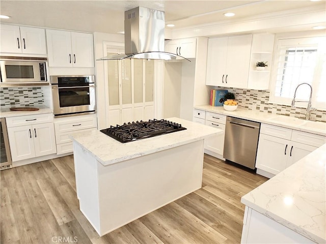 729 E Emerson Ave, Orange, CA 92865 - kitchen featuring island exhaust hood, tasteful backsplash, a sink, stainless steel appliances, and white cabinetry