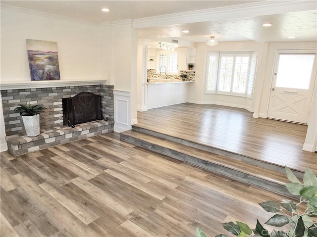 729 E Emerson Ave, Orange, CA 92865 - unfurnished living room featuring a brick fireplace, recessed lighting, crown molding, and wood finished floors