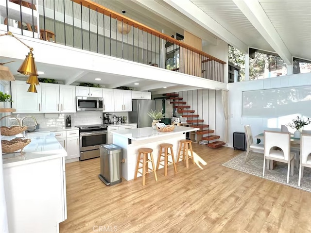 2012 Poplar Dr, Running Springs, CA 92382 - kitchen featuring stainless steel appliances, beam ceiling, a sink, light countertops, and decorative backsplash