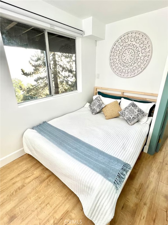 bedroom featuring baseboards and wood finished floors