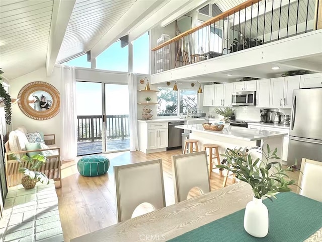 2012 Poplar Dr, Running Springs, CA 92382 - dining room featuring light wood-style floors, beam ceiling, and high vaulted ceiling