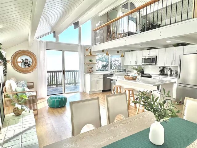 2012 Poplar Dr, Running Springs, CA 92382 - dining room with light wood-style flooring, beamed ceiling, and high vaulted ceiling