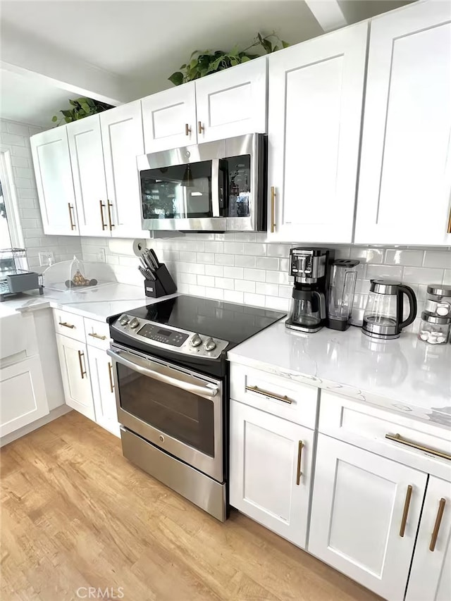 2012 Poplar Dr, Running Springs, CA 92382 - kitchen featuring stainless steel appliances, white cabinets, backsplash, and light wood-style floors
