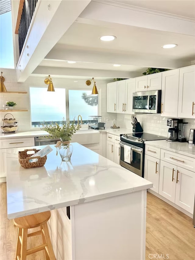 2012 Poplar Dr, Running Springs, CA 92382 - kitchen featuring appliances with stainless steel finishes, a center island, tasteful backsplash, light stone countertops, and recessed lighting