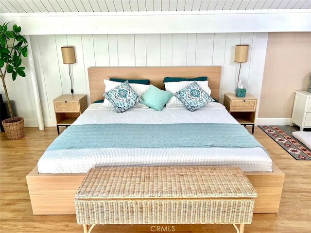 bedroom featuring baseboards and wood finished floors