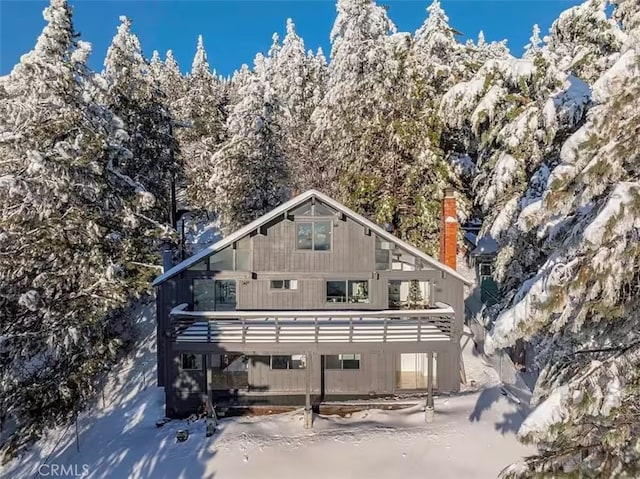 snow covered property featuring a chimney