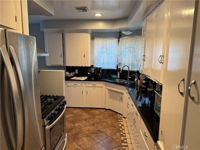 812 N Dickel St, Anaheim, CA 92805 - kitchen featuring a sink, appliances with stainless steel finishes, dark countertops, white cabinets, and tasteful backsplash