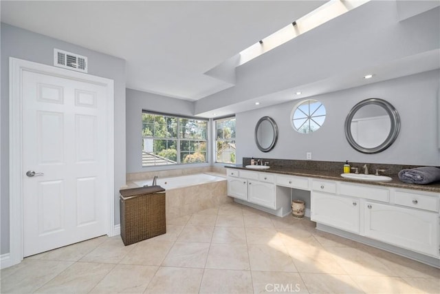 full bath featuring visible vents, a sink, a bath, and double vanity