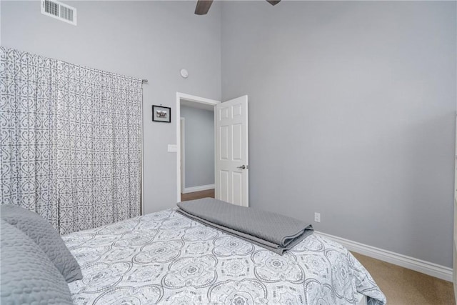 bedroom featuring carpet floors, high vaulted ceiling, visible vents, and baseboards