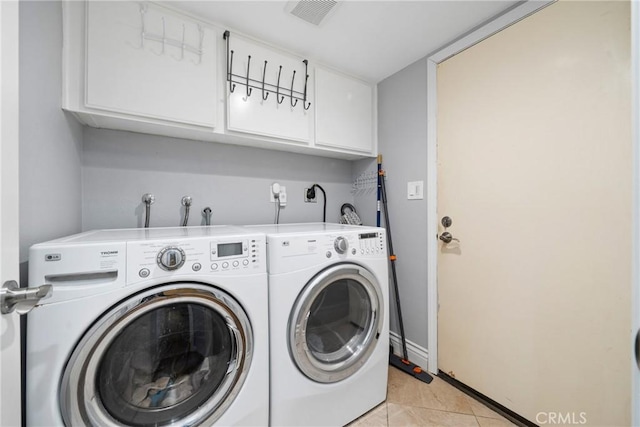 clothes washing area with visible vents, cabinet space, baseboards, light tile patterned flooring, and washer and dryer