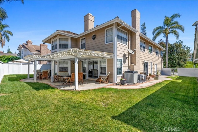 rear view of property with a yard, a pergola, a chimney, and a patio area