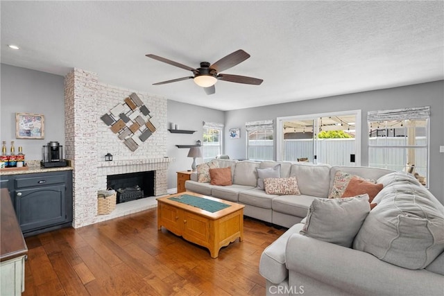 living room with recessed lighting, a fireplace, a ceiling fan, and dark wood-style floors